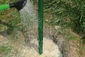 Water wordt met een gieter op het beton van de Fix tuin- en landschapsarchitectuur gegoten.