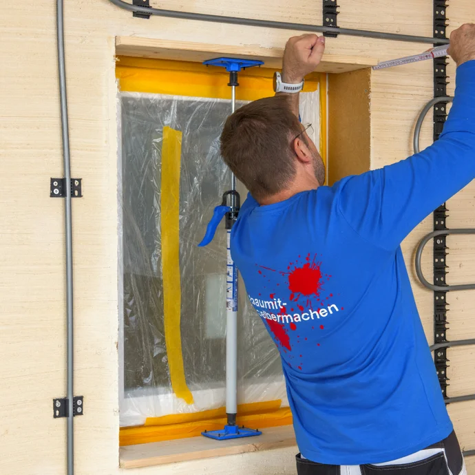 Heimwerker misst Fenster&ouml;ffnung f&uuml;r Renovierung mit Baumit-Produkten aus.