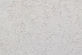 Close-up van de afgewerkte pleisterstructuur van de Munich roughcast op de gevel.
