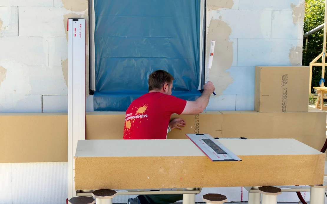 Die Holzfaserd&auml;mmplatte GUTEX Thermowall L wird als WDVS an die Fassade geklebt.
