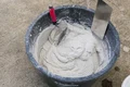 Meng Munchen roughcast in de mortelemmer met troffel en vlakspaan - klaar voor aanbrengen.
