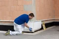 De plintisolatieplaat wordt vastgelijmd aan het metselwerk.